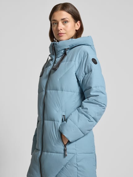 Frauenmodel trägt Steppjacke mit 10.000 mm Wassersäule Modell 'GW30' von G.I.G.A. DX in Hellblau, glatte Oberfläche, Nahaufnahme Oberkörper. Regular Fit mit Kapuze, Zweiwege-Reißverschluss und Reißverschlusstaschen, Kontext: Rückenlänge 84 cm, Schulterbreite 47 cm, Brustweite 49 cm, Ärmellänge 63 cm.