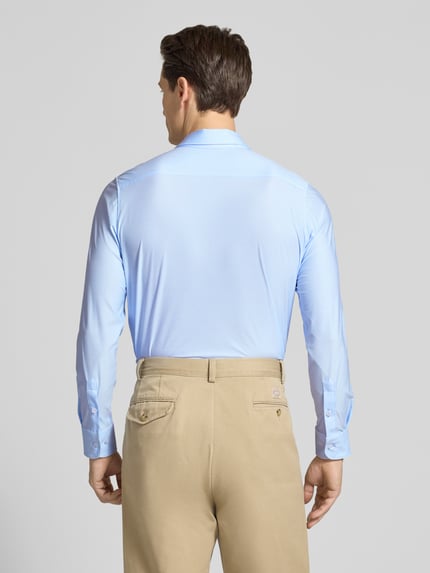 Männermodel trägt Slim Fit Businesshemd mit Knopfleiste von CRUNA, hellblau, glatte Textur, Kentkragen, Rückenansicht, Ganzkörperansicht.