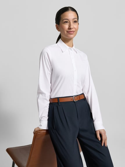 Frauenmodel trägt Regular Fit Hemdbluse aus reiner Baumwolle Modell 'ESSENTIAL' von HUGO, unifarben weiß, Popeline, Langarm, Knopfleiste, Ganzkörperansicht von vorne.