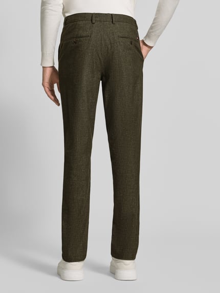 Männermodel trägt Slim Fit Gerade Hose aus Baumwoll-Mix mit Viskose-Anteil Modell 'DENTON' von Tommy Hilfiger in Dunkelgrün, Ganzkörperansicht Rückansicht. Herren Gerade Hose von Tommy Hilfiger