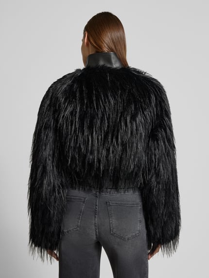 Frauenmodel trägt Slim Fit Jacke in Kunstfell-Optik Modell 'CECOOL' von BOSS in Schwarz, Stehkragen, Langarm, gerippter Bund, Ganzkörperansicht Rückansicht.