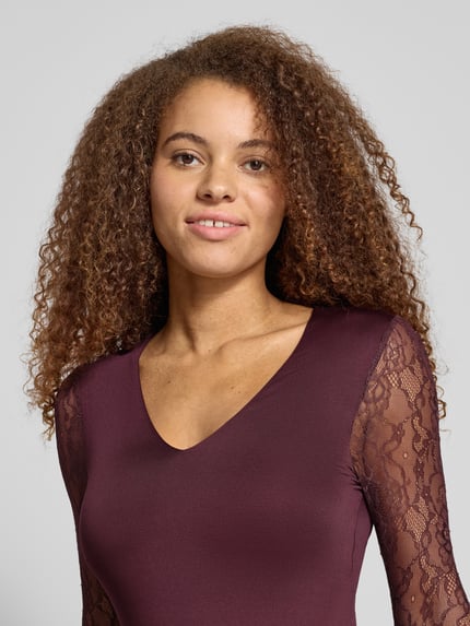 Frauenmodel trägt Slim Fit Body mit Spitzenärmeln Modell 'SIA' von Only in Dunkelrot, unifarben, Stretch-Webstruktur, Nahaufnahme Oberkörper.