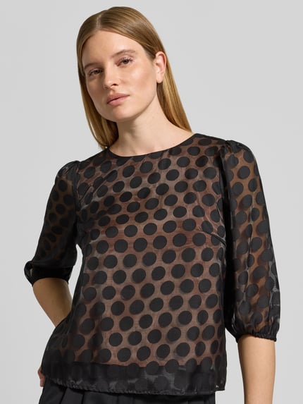 Frauenmodel trägt Semitransparentes Blusenshirt im Allover-Look von Christian Berg Woman Selection, Schwarz mit runden Punkten, Rundhalsausschnitt, 3/4-Arm, Material-Mix mit Viskose-Anteil, Regular Fit, Ganzkörperansicht von vorne.