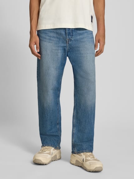 Męski model nosi Straight Fit Jeans aus reiner Baumwolle Modell 'ALEX' od JACK & JONES, niebieski denim, 5 kieszeni, zapięcie na guzik i zamek błyskawiczny, Szerokość w rozmiarze 32/32: 39 cm, Długość wewnętrzna nogawki: 73 cm, Ganzkörperansicht z przodu.