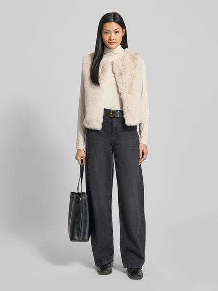 Frauenmodel trägt Weste aus Kunstfell mit Rundhalsausschnitt von Milano Italy in Beige, Regular-Fit, strukturierte Textur, Ganzkörperansicht von vorne. Rückenlänge 49 cm, Schulterbreite 41 cm, Brustweite 50 cm bei Größe 36.