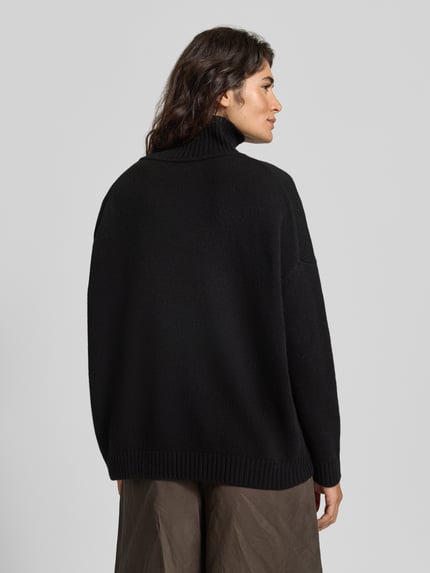 Frauenmodel trägt schwarzen Loose Fit Pullover aus reiner Wolle Modell 'BORGIA' von Max Mara für Weekend Max Mara, Ganzkörperansicht Rückansicht.