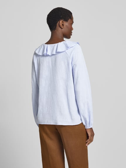 Frauenmodel trägt Regular Fit Bluse mit V-Ausschnitt und Volants von Christian Berg Woman aus reiner Baumwolle, hellblau, fein strukturiert, Ganzkörperansicht Rückansicht.