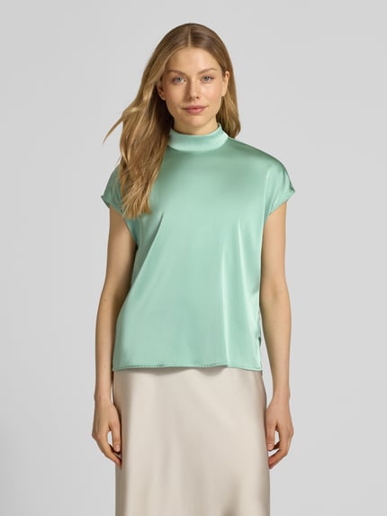 Frauenmodel trägt Blusenshirt mit Stehkragen von Jake*s Collection, mintgrün, Material-Mix mit Stretch-Anteil, Regular-Fit, Rückenreißverschluss, glatte Textur, Rückenlänge bei Größe 38 59 cm, Ganzkörperansicht von vorne.