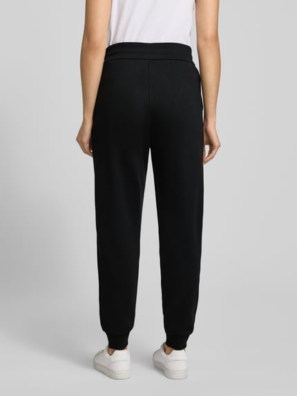 Kobiece modelka nosi czarne Sweatpants mit elastischem Bund od ARMANI EXCHANGE, bawełniany miks, luźny krój, widok całej sylwetki z tyłu.