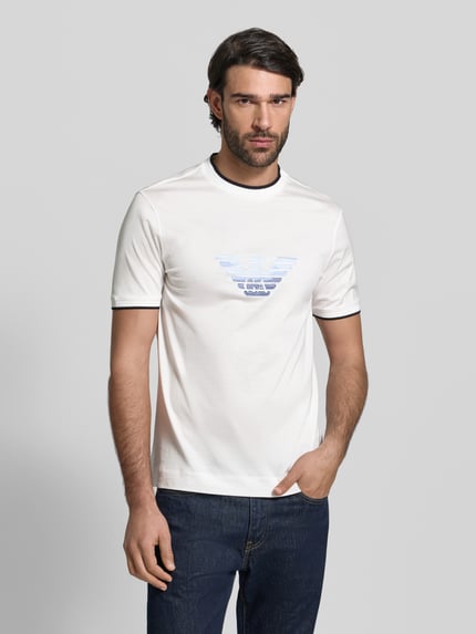 Männermodel trägt Regular Fit T-Shirt mit Logo-Stitching von Emporio Armani, weiß, aus Lyocell-Mix mit Baumwoll-Anteil, Nahaufnahme Oberkörper.