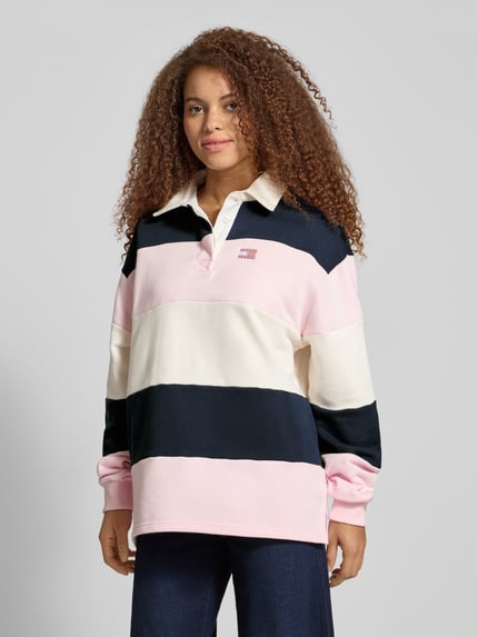 Frauenmodel trägt Regular Fit Pullover aus reiner Baumwolle von Tommy Jeans, mehrfarbig, Polokragen, Langarm, Sweat, Label-Stitching, Ganzkörperansicht von vorne.