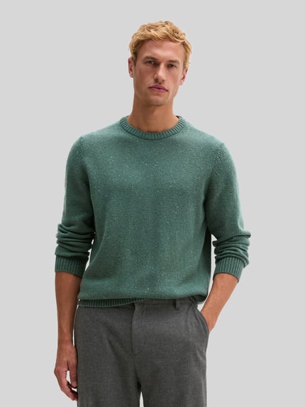 Männermodel trägt grünen Pullover mit Logo-Detail von MARC O'POLO, Strickoptik, Struktur, Regular Fit, Nahaufnahme Oberkörper.