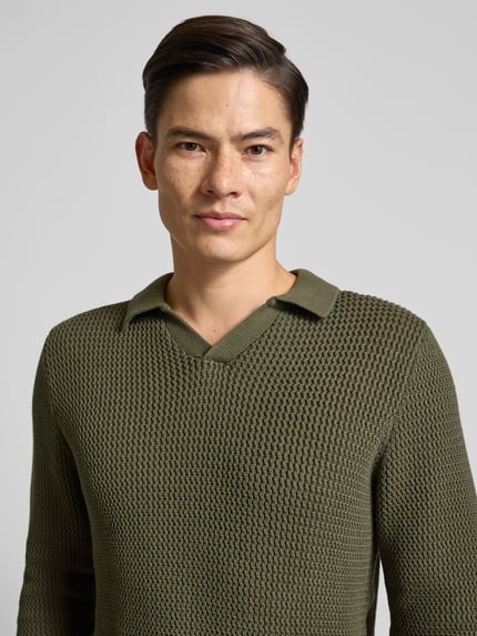Männermodel trägt Strickpullover mit gerippten Abschlüssen von MCNEAL in Olivgrün, reine Baumwolle, Regular-Fit, Nahaufnahme Oberkörper.