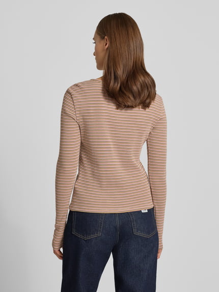 Frauenmodel trägt Slim Fit Langarmshirt aus reiner Baumwolle von REVIEW, feine Streifen in Beige und Weiß, Rundhalsausschnitt, Rückenansicht, Detail aus dem Kontext: Damen Langarmshirt, Knopfleiste, Rückenlänge bei Größe S 50 cm, Ganzkörperansicht Rückansicht.