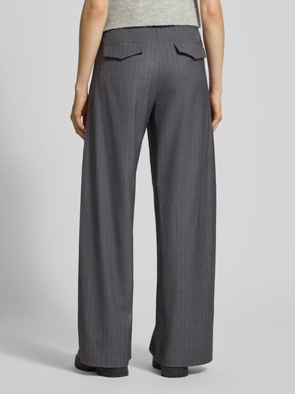Kobiece modelka nosi Stoffhose mit Label-Detail Modell 'Leana' od OH APRIL, szara z cienkimi paskami, luźny krój, widok całej sylwetki z tyłu.