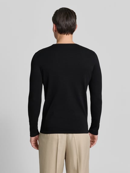 Männermodel trägt schwarzen Slim Fit Pullover in Strick-Optik Modell 'Mino' von Drykorn, reine Baumwolle, Rückenansicht, Ganzkörperansicht Rückansicht.