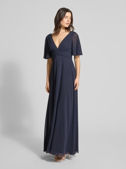 Kobiece modelka nosi Regular Fit Abendkleid mit V-Ausschnitt von Jake*s Cocktail z szyfonu, krój regular fit, dekolt w serek, efekt plisowania, rękaw o dł. 1/2, dekolt na plecach, wszyty zamek błyskawiczny, nieprzezroczysta halka, długość tyłu w rozmiarze 36: 126 cm, szerokość w rozmiarze 36: 40 cm, długość rękawów w rozmiarze 36: 29 cm, kolor granatowy, gładka tekstura, pełny widok od frontu.