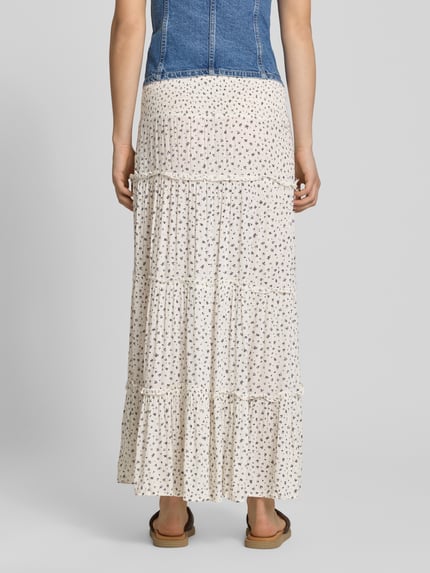 Vrouwenmodel draagt Maxi-Rock aus reiner Viskose Modell 'FERNANDA' van Only, allover-print, uitlopend, ruches, crêpe, witte tinten, maxi lengte, gesmokte tailleband. Volledige lichaamsaanzicht achteraan.