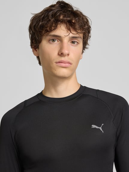 Mannelijk model draagt zwart Slim Fit Sport-T-Shirt met Logo-Print Modell 'PWRMODE' van PUMA Performance, Nahaufnahme bovenlichaam.