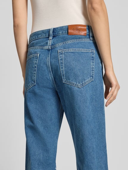 Frauenmodel trägt Straight Fit Jeans im Destroyed-Look von Calvin Klein Jeans in Blau, reine Baumwolle, Label-Detail, Ganzkörperansicht Rückansicht.