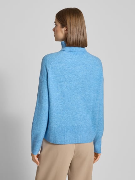 Frauenmodel trägt Regular Fit Rollkragenpullover aus Schurwoll-Mix von Marc O'Polo Denim in Melange-Optik, gestrickt, Ganzkörperansicht Rückansicht.