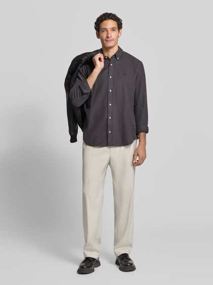 Männermodel trägt Regular Fit Freizeithemd aus reiner Baumwolle mit Label-Stitching von MCNEAL in Grau, Ganzkörperansicht von vorne. Kontext: Freizeitmode für Herren, Button-Down-Kragen, Rückenlänge 74 cm, Schulterbreite 50 cm, Ärmellänge 66 cm.