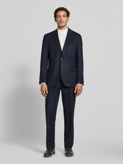 Männermodel trägt donkerblauwe Anzughose mit Bügelfalte und Eingrifftaschen van Christian Berg Men, Materiaalmix met scheerwol, straight fit, knoop-, haak- en ritssluiting, persplooien, Franse steekzakken, strookzak aan de achterkant, bandwijdte maat 50: 47 cm, binnenbeenlengte maat 50: 82 cm, ganzkörperansicht van voren.