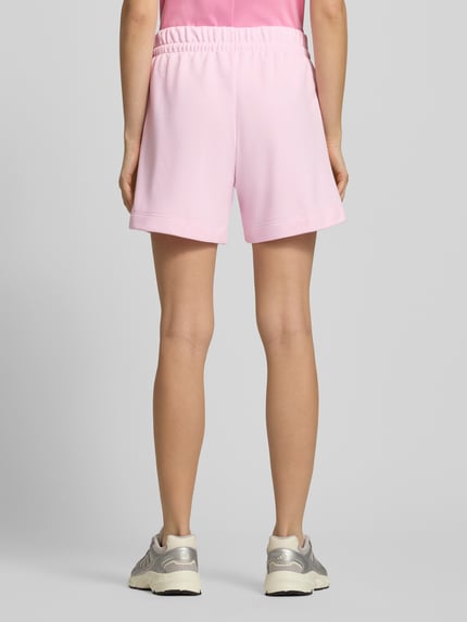 Frauenmodel trägt Shorts mit elastischem Bund und Tunnelzug von adidas Sportswear in Rosa, Baumwoll-Mix, Ganzkörperansicht Rückansicht.