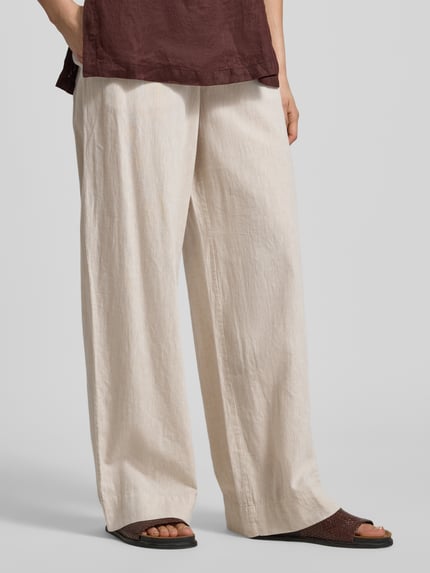 Vrouwenmodel draagt Regular Fit wijdte broek uit mix van linnen en katoen model 'LUISA' van Selected Femme met mêlee look, tunnelkoord, elastische boord, zij-steekzakken, achterzakken, flammgaren materiaalverwerking, nahaufnahme onderlichaam.