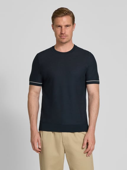 Männermodel trägt Regular Fit T-Shirt aus Strick Modell 'H-NALON' von BOSS in Strickoptik, Baumwoll-Mix, Dunkelblau, Ganzkörperansicht von vorne.