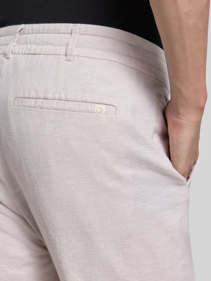 Męski model nosi Straight Leg Hose aus Leinen-Baumwoll-Mix von Tom Tailor Denim, jasny jednokolorowy materiał, tylna perspektywa, zbliżenie na biodra, kieszenie z przodu i z tyłu, krój straight leg, len z bawełną.