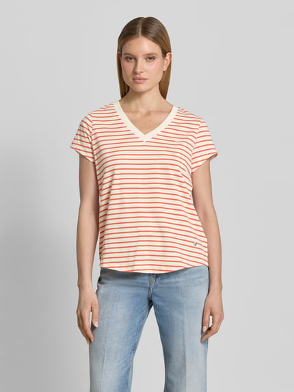 Kobiece modelka nosi damski t-shirt z mieszanki bawełny i elastanu, prosty krój, model 'Kala' z dekoltem w serek od MOS MOSH, długość tyłu w rozmiarze S: 63 cm, widok całej sylwetki z przodu