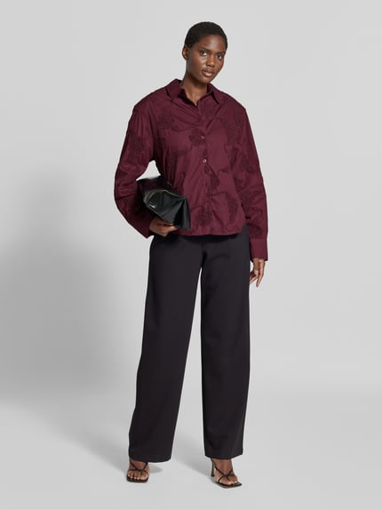 Männermodel trägt Oversized Hemdbluse aus reiner bawełna von ROTATE, hafty kwiatowe, krój oversized, długi rękaw, listwa guzikowa, kolor ciemnoczerwony, Na całej długości, Długość tyłu w rozmiarze 36: 70 cm, Długość rękawów w rozmiarze 36: 63 cm, Ganzkörperansicht von vorne