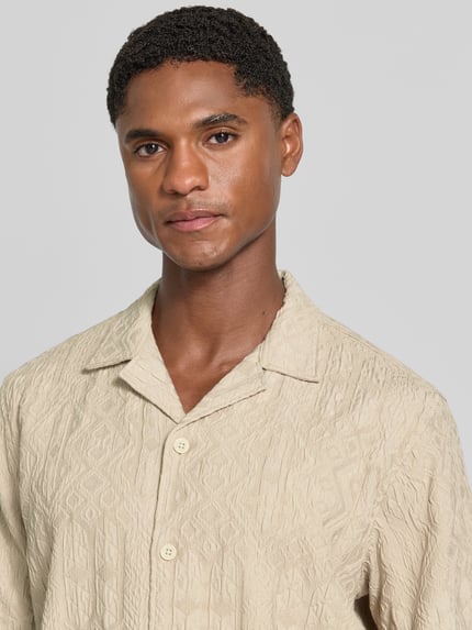 Männermodel trägt Modern Fit Freizeithemd mit Strukturmuster von Lindbergh in Beige, Reverskragen, Viskose-Mix, Nahaufnahme Oberkörper.