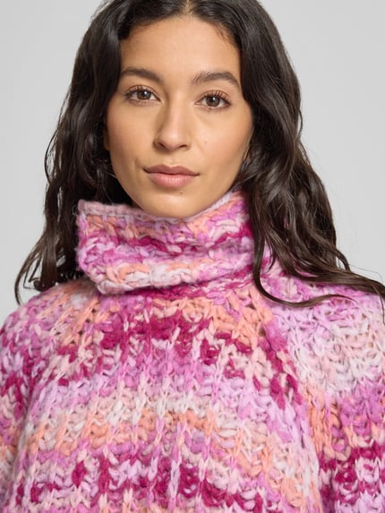 Vrouwenmodel draagt Strickpullover mit Rollkragen van Smith and Soul in grofgebreid roze-mix met alpaca en relaxed fit, nahaufnahme bovenlichaam.