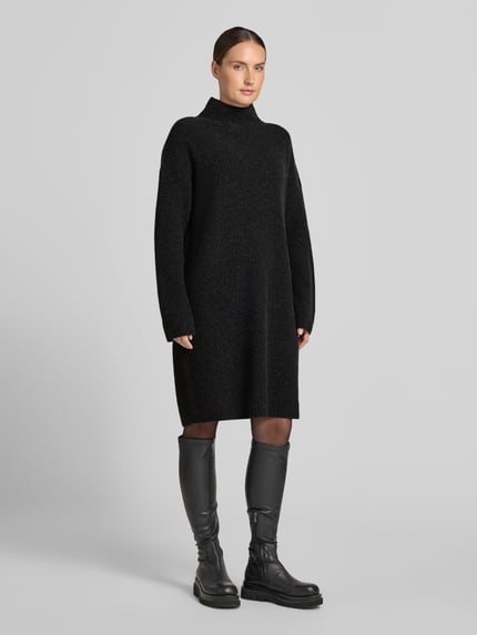 Frauenmodel trägt Loose Fit Strickkleid aus Woll-Mix von Marc O'Polo, schwarz, grobe Strickstruktur, Ganzkörperansicht von vorne. Damen Strickkleid von Marc O'Polo.