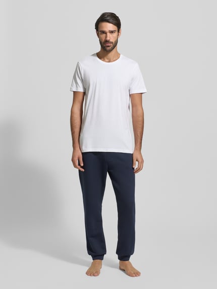 Männermodel trägt weißes T-Shirt mit Rundhalsausschnitt im 2er-Pack von Christian Berg Men in Slim Fit aus reiner Baumwolle, Ganzkörperansicht von vorne.