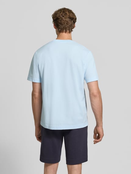 Männermodel trägt Regular Fit T-Shirt aus reiner Baumwolle von Lacoste in Hellblau mit glatter Textur, Ganzkörperansicht Rückansicht. Herren T-Shirt von Lacoste.