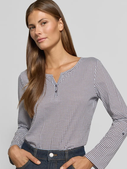 Frauenmodel trägt Regular Fit Langarmshirt aus reiner Baumwolle von Tom Tailor, geometrisches Muster in Weiß und Dunkelblau, Nahaufnahme Oberkörper, Damen Langarmshirt von Tom Tailor.