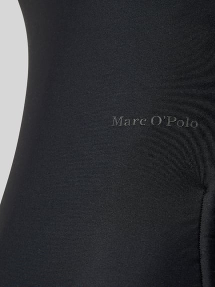 Frauenmodel trägt Badeanzug mit Label-Schriftzug Modell 'ABSTRACT FLORAL' von Marc O'Polo, Optik: Unifarben, Materialverarbeitung: Stretch, Nahaufnahme Oberkörper.