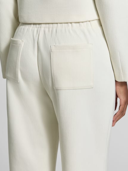 Frauenmodel trägt Cordhose mit elastischem Bund von Christian Berg Woman aus Baumwoll-Mix in Creme mit Gesäßtaschen, Nahaufnahme Rückansicht.