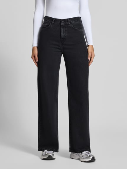 Kobiece model nosi czarne jeansy Wide Leg Jeans aus reiner Baumwolle Model 'Jane' od Carhartt Work In Progress, bawełna, 5 kieszeni, zapięcie na guzik i zamek błyskawiczny, Szerokość w rozmiarze 27: 38 cm, Długość wewnętrzna nogawki w rozmiarze 27: 81 cm, widok całej sylwetki z przodu.