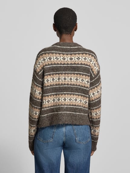 Frauenmodel trägt Pullover mit überschnittenen Schultern Modell 'VMISOLA' von VERO MODA in mehrfarbiger Strickoptik, Ganzkörperansicht Rückansicht.