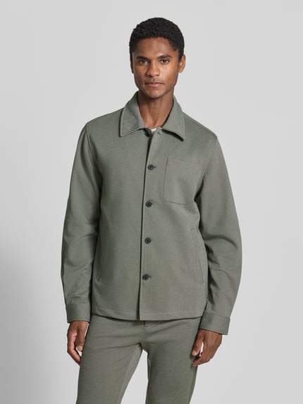 Männermodel trägt Slim Fit Hemdjacke mit Viskose-Anteil von Lindbergh in Grau, Umlegekragen, Knopfleiste, Brusttasche, Ganzkörperansicht von vorne.