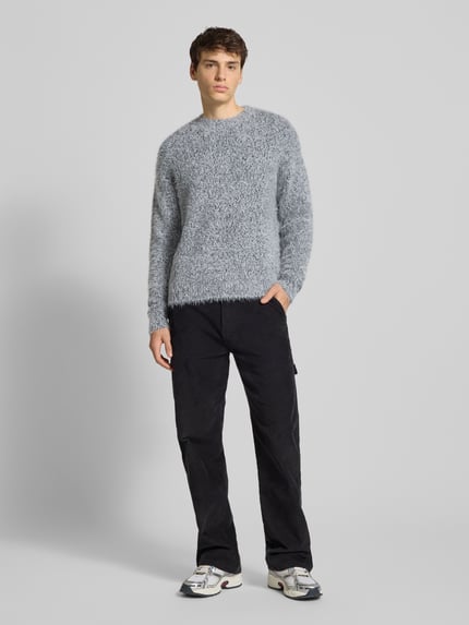 Männermodel trägt Regular Fit Strickpullover mit Alpaka-Anteil Modell 'NOAH' von Only & Sons in melierter Optik, Ganzkörperansicht von vorne.