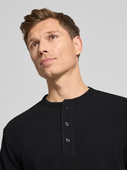 Männermodel trägt Regular Fit Pullover mit Knopfleiste Modell 'Kilano' von Drykorn, Baumwoll-Mix, Strukturmuster, Nahaufnahme Oberkörper.