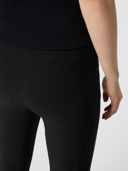 Vrouwenmodel draagt Stoffen broek met steekzakken van Christian Berg Woman, viscosemix met stretch, recht model, detailopname achterkant.