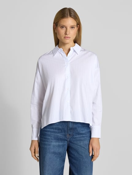 Frauenmodel trägt Relaxed Fit Bluse mit verlängertem Rückenteil Modell 'CLOELIA' von Drykorn aus reiner Baumwolle, Ganzkörperansicht von vorne