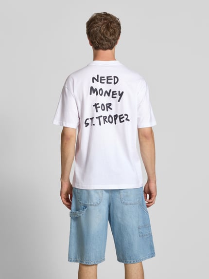 Męski model nosi Loose Fit T-Shirt aus reiner Baumwolle Modell 'MONEY' von Only & Sons, biały, z nadrukiem, krój loose fit, widok całej sylwetki z tyłu.