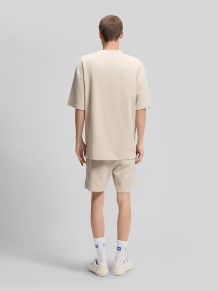 Męski model nosi Relaxed Fit T-Shirt aus Baumwoll-Mix Modell 'NUWAFFLE' von HUGO, efekt: jednolity kolor, faktura, aplikacja z wyhaftowanym logo, okrągły dekolt, krótki rękaw, mieszanka bawełny, Ganzkörperansicht Rückansicht.